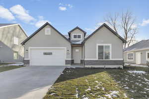 View of front of house featuring a garage and a yard