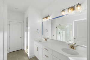 Bathroom with tile patterned flooring, vanity, and walk in shower