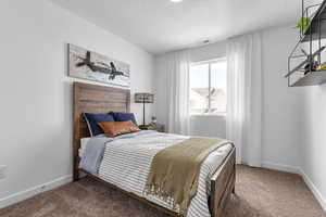 Carpeted bedroom featuring a textured ceiling