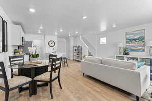 Dining room with sink, a textured ceiling, and light wood-type flooring