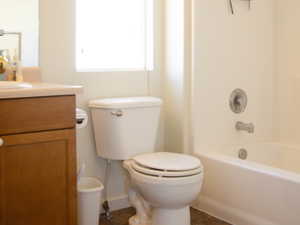 Full bathroom with tile patterned floors, vanity, bathing tub / shower combination, and toilet