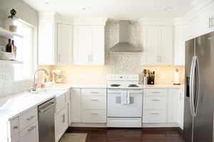 Kitchen featuring white cabinetry, sink, wall chimney range hood, dark hardwood / wood-style floors, and appliances with stainless steel finishes