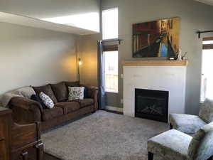 Living room featuring carpet floors and a tiled fireplace