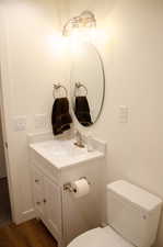 Bathroom featuring hardwood / wood-style floors, vanity, and toilet