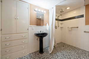 Bathroom featuring tile patterned floors, a shower with curtain, and tile walls