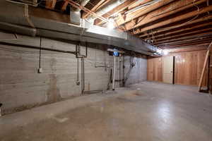 Unfinished utility room with laundry hookups and storage space