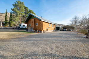 View of property exterior featuring central AC unit and a carport