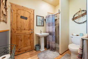 Bathroom featuring toilet, wood-type flooring, and walk in shower