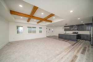 Living room with beam ceiling, light wood-type flooring, coffered ceiling, and sink