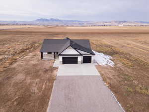 View of front facade with a mountain view, a garage, and a rural view