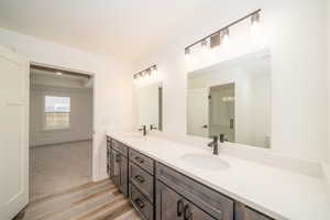 Bathroom with hardwood / wood-style floors, vanity, and toilet