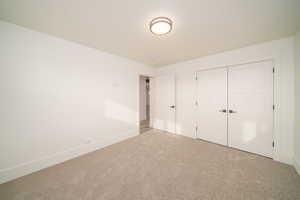 Unfurnished bedroom featuring carpet and a closet