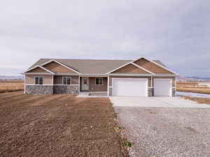 View of front of property with a porch and a garage