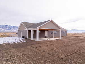 View of front of house with a mountain view and a patio