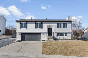 Raised ranch featuring a front yard and a garage