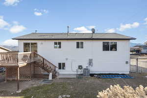 Rear view of house with a deck and cooling unit