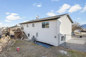 Rear view of house featuring a deck and central AC unit