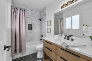 Full bathroom with shower / bath combo, tile patterned floors, a textured ceiling, toilet, and vanity