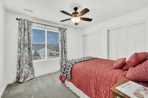 Carpeted bedroom featuring ceiling fan