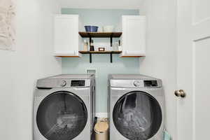 Clothes washing area with cabinets and washer and clothes dryer