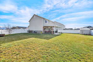 Rear view of property featuring a lawn and a patio