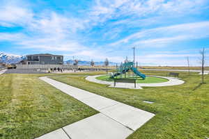 View of jungle gym featuring a mountain view and a yard