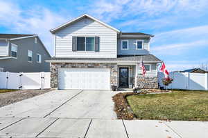 View of property with a garage and a front lawn