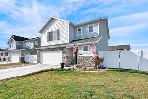 Front of property with a garage and a front lawn