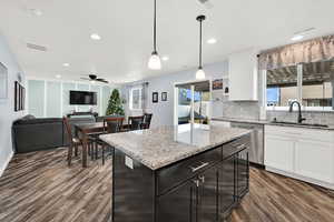 Kitchen with dark hardwood / wood-style flooring, ceiling fan, dishwasher, and hanging light fixtures