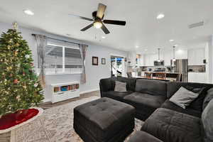 Living room featuring ceiling fan, a healthy amount of sunlight, and wood-type flooring