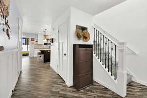 Stairs with a chandelier, hardwood / wood-style floors, and a textured ceiling