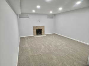 Unfurnished living room with a fireplace and carpet floors