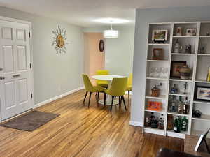 Dining room with hardwood / wood-style flooring and a textured ceiling