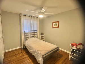 Bedroom with dark hardwood / wood-style flooring and ceiling fan