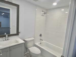 Full bathroom featuring vanity, toilet, and tiled shower / bath combo