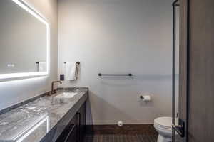 Bathroom with toilet, vanity, and tile patterned floors