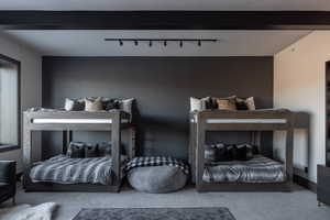 Bedroom with carpet floors and rail lighting