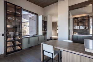 Interior space featuring stainless steel oven, wooden ceiling, and dark wood-type flooring