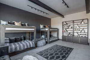 Carpeted bedroom featuring beamed ceiling