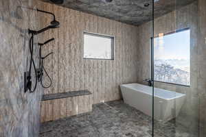 Bathroom featuring a healthy amount of sunlight, tile walls, and shower with separate bathtub