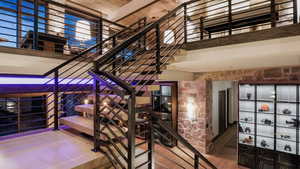 Wine area with hardwood / wood-style flooring and a towering ceiling