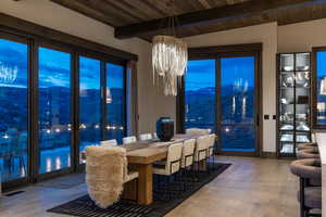 Dining space with a mountain view, light wood-type flooring, an inviting chandelier, and wood ceiling