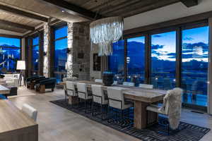 Dining space featuring floor to ceiling windows, wood ceiling, wood-type flooring, beamed ceiling, and a mountain view