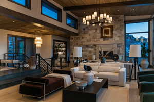 Living room with beamed ceiling, light hardwood / wood-style flooring, a fireplace, and wooden ceiling