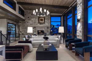 Living room with wood ceiling, wood-type flooring, beam ceiling, an inviting chandelier, and high vaulted ceiling