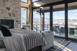 Bedroom featuring multiple windows, a mountain view, a fireplace, and hardwood / wood-style flooring