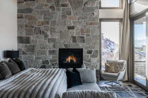 Bedroom with multiple windows and a stone fireplace