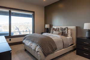 Bedroom with a mountain view, light carpet, and multiple windows