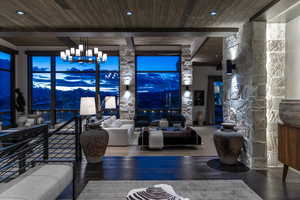 Living room featuring wooden ceiling, beamed ceiling, a chandelier, and hardwood / wood-style flooring