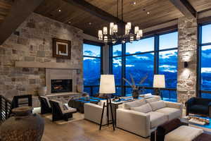 Living room featuring hardwood / wood-style floors, beam ceiling, wooden ceiling, a chandelier, and a high ceiling